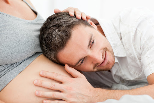 Husband listening to his wife&#8217;s belly &#8211; pt