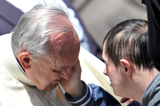 A down’s syndrome boy caresses Pope Francis – pt