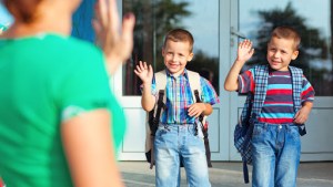 Two brothers waving back at their mother on their first day at school – pt