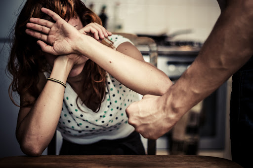Woman covering her face in fear of domestic violence &#8211; pt