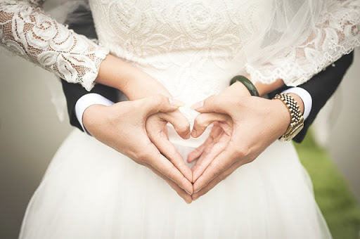 pareja de recién casados formando un corazón con sus manos &#8211; pt
