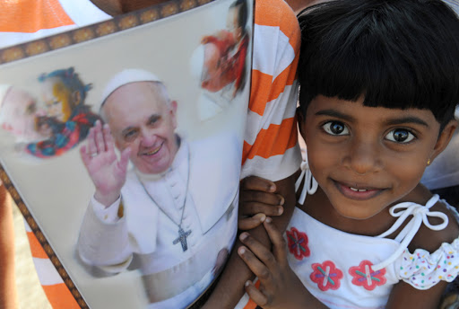 A young Sri Lankan holds paraphernalia bearing the portrait of Pope Francis &#8211; pt