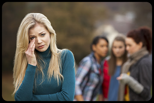 Upset Teenage Girl With Friends Gossiping In Background &#8211; © Oliveromg / Shutterstock &#8211; pt
