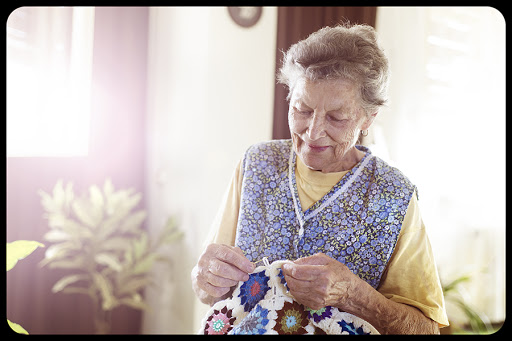 Old woman is knitting a blanket inside in her living room © Halfpoint / Shutterstock &#8211; pt