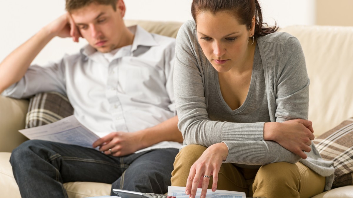 Annoyed couple calculating their finances during recession