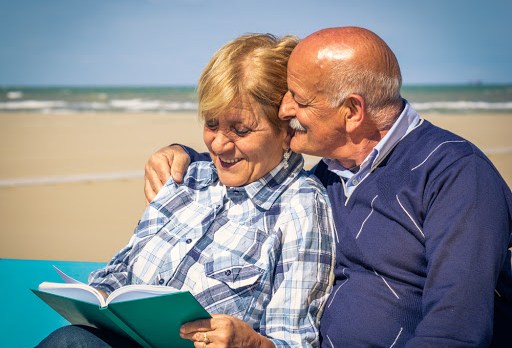 Old happy couple looking at their photo album – fr