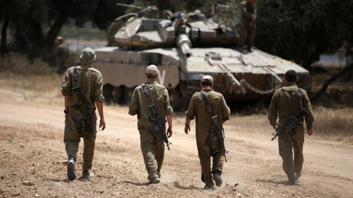 Israeli soldiers walk towards a Merkava tank – AFP – fr