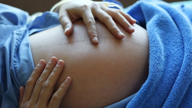 HERO-WOMAN-PREGNANT-BELLY-HANDS-HOSPITAL-Sakhorn-Shutterstock_125744078