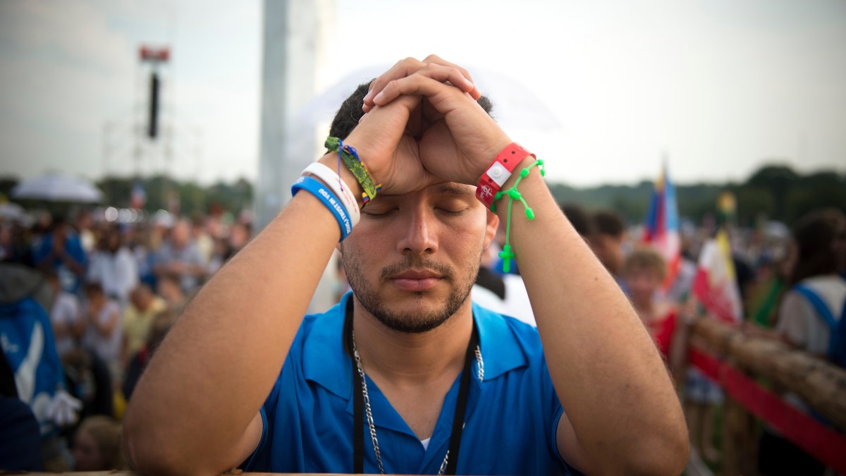web-wyd-krakow-young-man-praying-jeffrey-bruno-cna