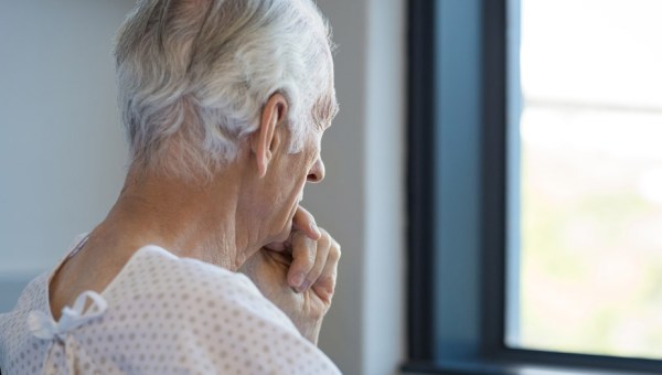 HOMEM OLHANDO PELA JANELA DO HOSPITAL