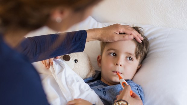 WEB3 MOM AND SON SICK FEVER THERMOMETER CAREGIVER Shutterstock