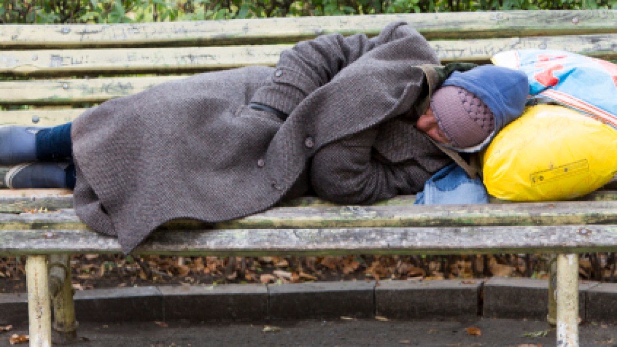 Homeless man sleeping on a bench