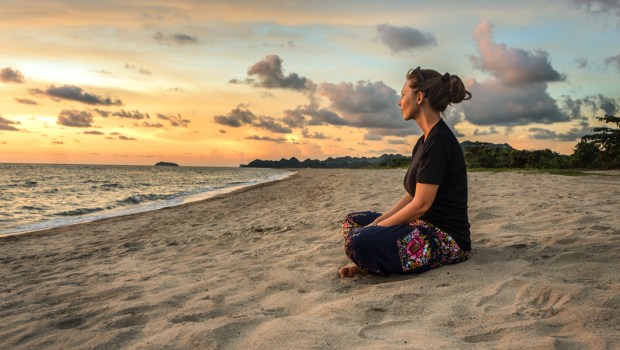 WOMAN SITTING ON BEACH
