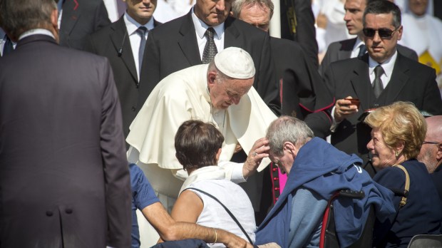 Pope Francis blesses a disable man
