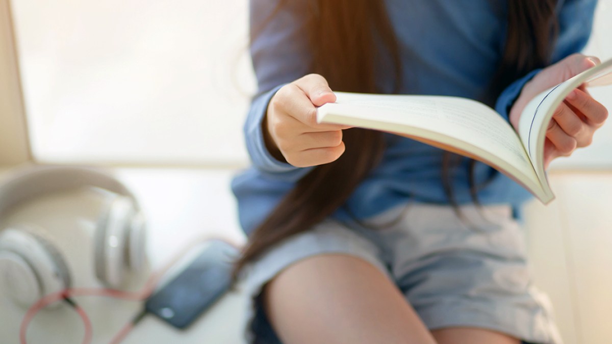 WEB3-CHILD-READING-BOOK-GIRL-HEADPHONES-PHONE-SMARTPHONE-Shutterstock