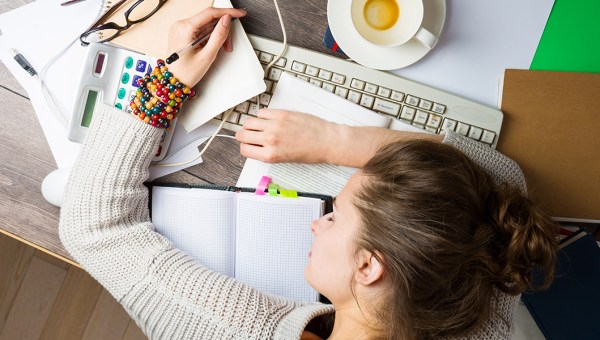 ZMĘCZONA KOBIETA ŚPI NA BIURKU