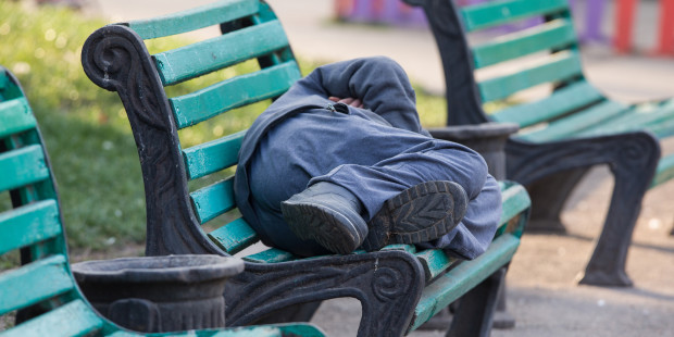 MAN SLEEPING ON BENCH