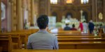 ASIAN MAN PRAYING IN CHURCH