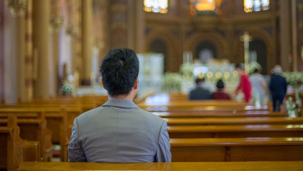 ASIAN MAN PRAYING IN CHURCH