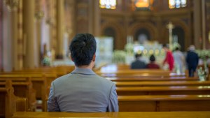 ASIAN MAN PRAYING IN CHURCH