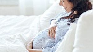 PREGNANT WOMAN LYING IN BED