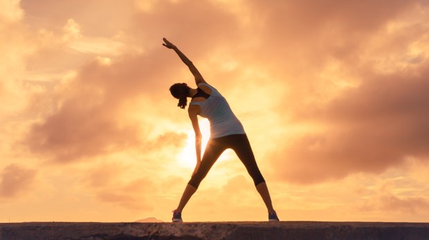 WOMAN,STRETCHING,SUNSET