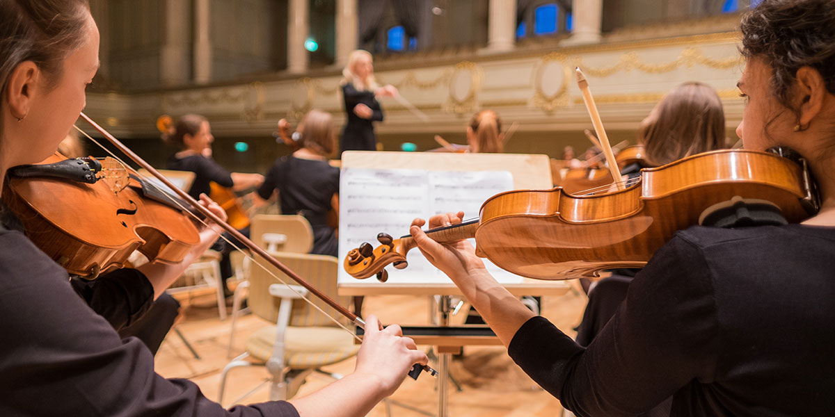 MÚSICOS TOCANDO VIOLINO EM ORQUESTRA