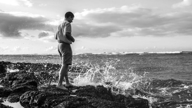Homem pensativo junto ao mar evoca fato de que é inevitável sofrer