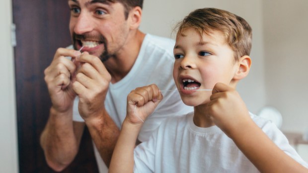 little boy with his father cleaning teeth