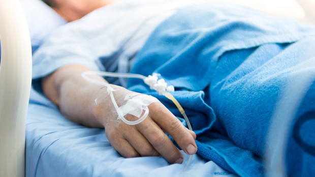 Enfermo em leito de hospital representa a necessidade cristã de rezar pelas pessoas que estão morrendo