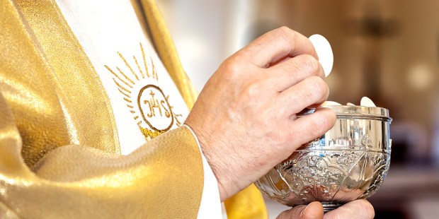 Eucaristia: um padre e a comunhão