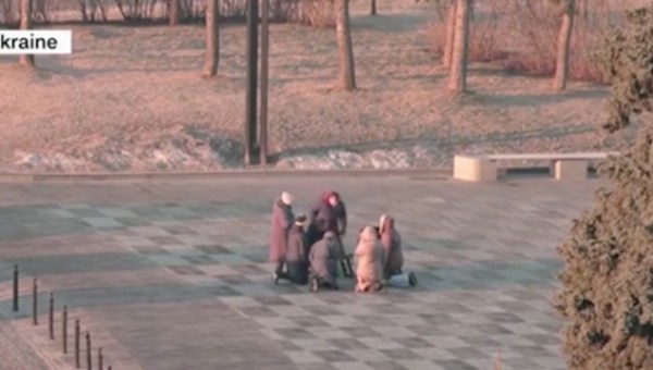 Pessoas rezando na rua em Kharkiv, Ucrânia