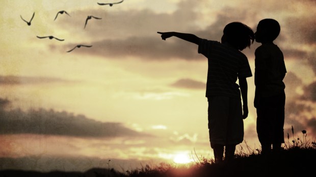 Crianças apontando para o por do sol