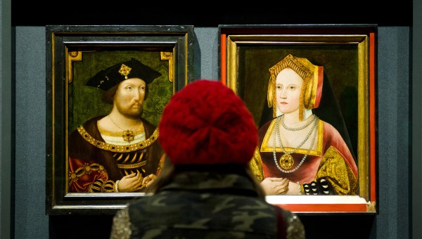 A woman looks at portraits of English King Henry VIII and his first wife Catherine of Aragon