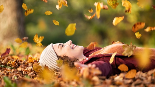 mulher feliz sorri com gratidão na natureza