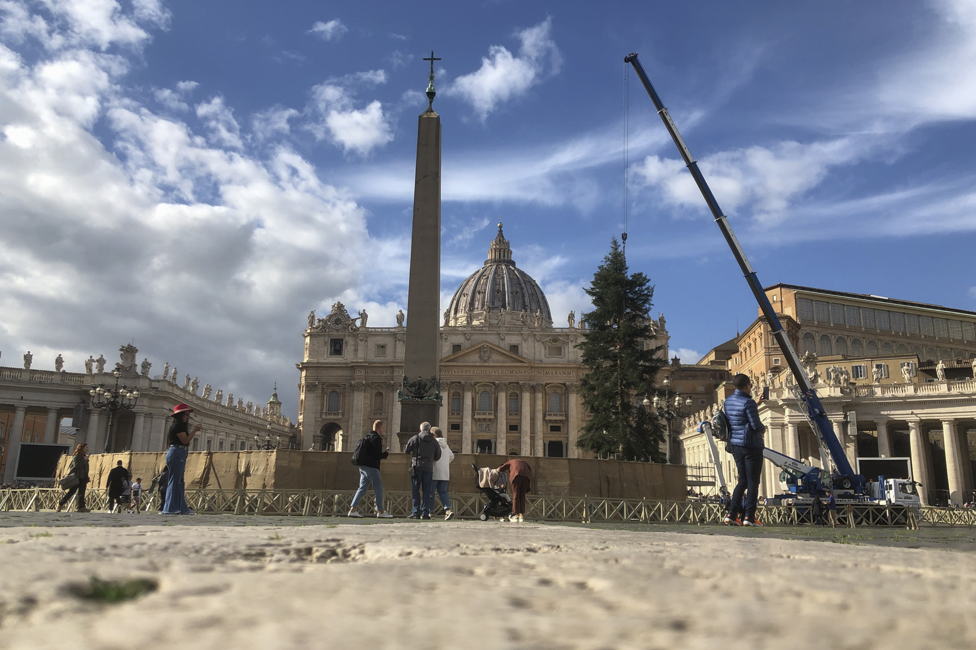 Workers-look-on-as-a-crane-lifts-a-Christmas-Tree-silver-fir-from-the-Abruzzo-region-into-position-at-St-Peters-Square