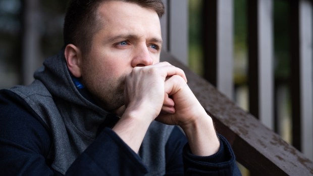 Sad caucasian man sitting alone and thinling about problems