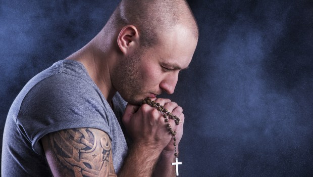 Handsome young man with tattoo isolated on black