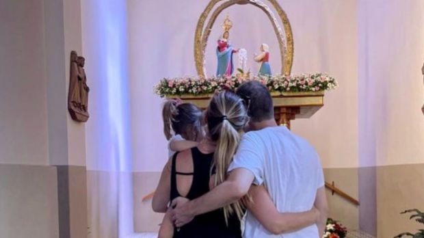 Tiago Leifert abraçado com a esposa e filha em igreja