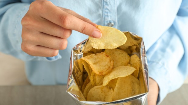 Woman-eating-tasty-potato-chips-closeup-shutterstock