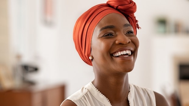 Mulher negra com turbante sorrindo