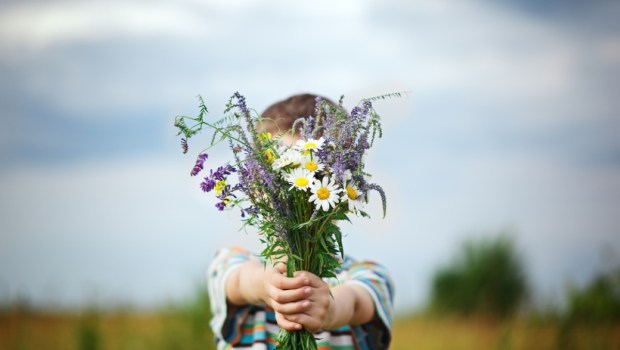 Criança oferecendo flores