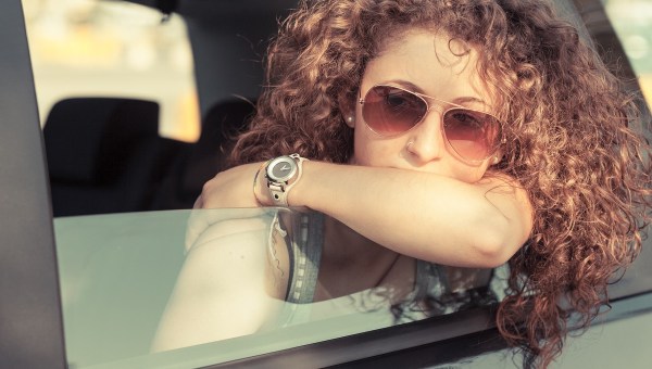 Sad girl looks out car window