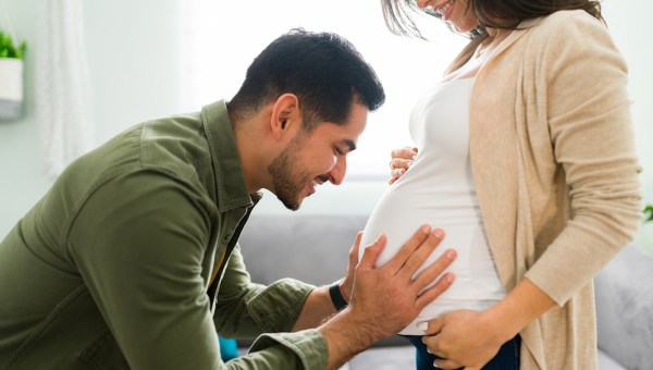 Homem conversa com bebê no ventre da esposa