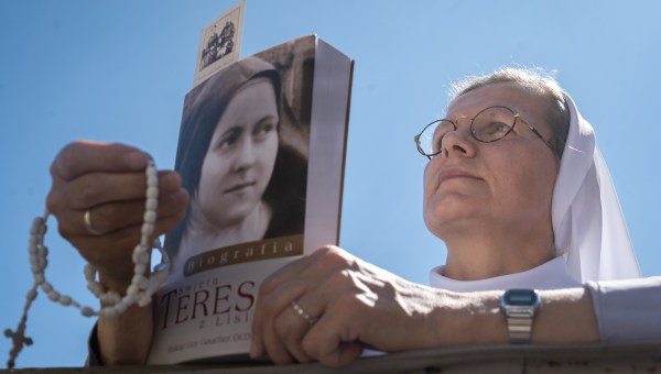 Freira segura livro de Santa Teresinha
