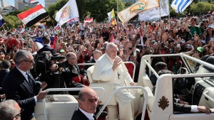 Pilgrims cheer and wave flags as Pope Francis arrives for the welcoming ceremony of World Youth Day