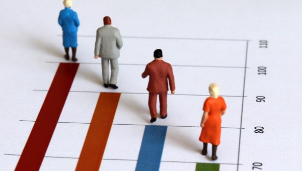 miniature figures walk along graph representing years of age