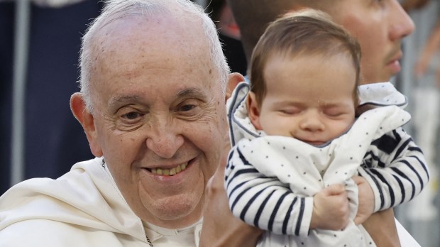 Papa Francisco segura bebê ao chegar ao Estádio Velodrome, em Marselha, França