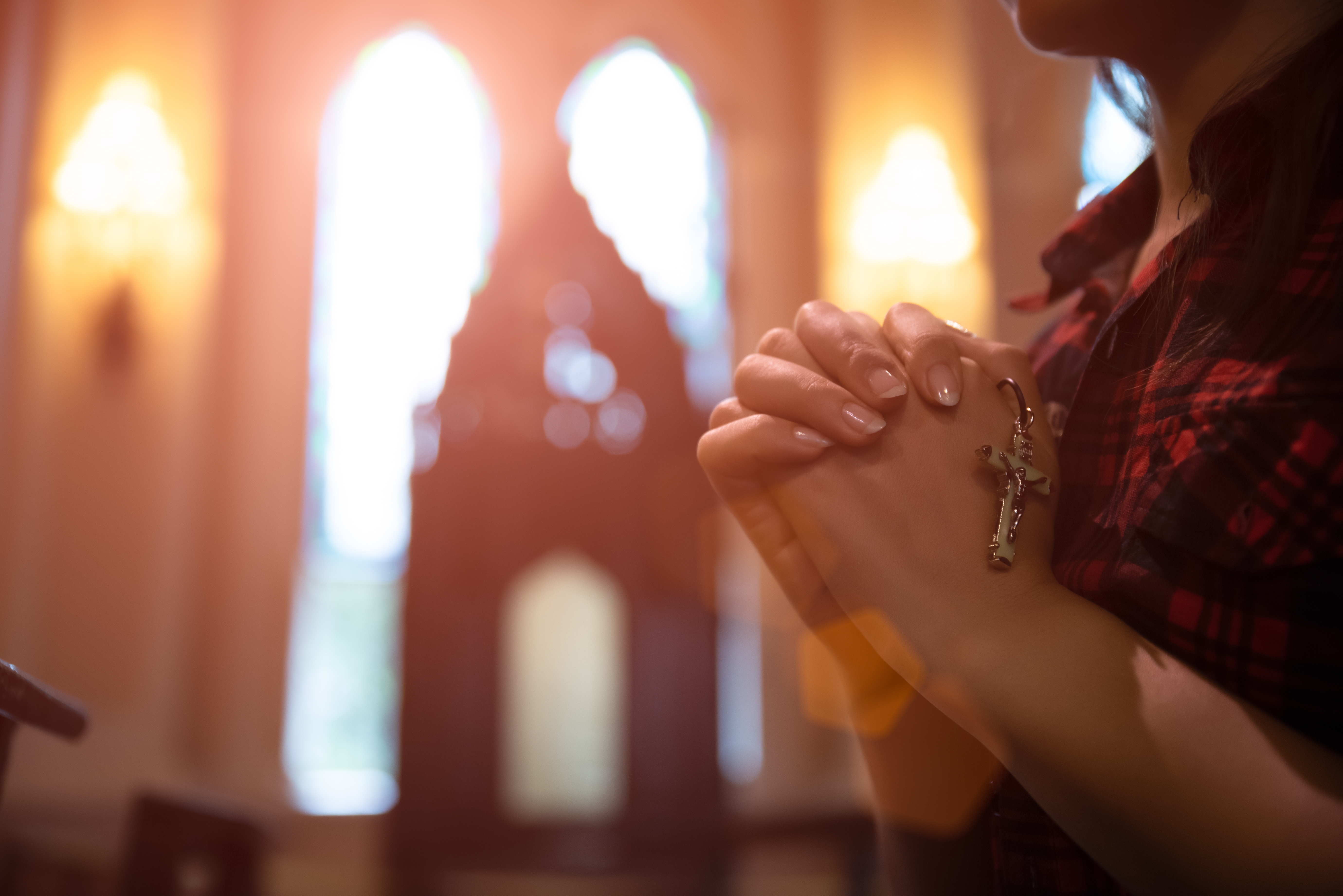 Woman praying with rosary in hands