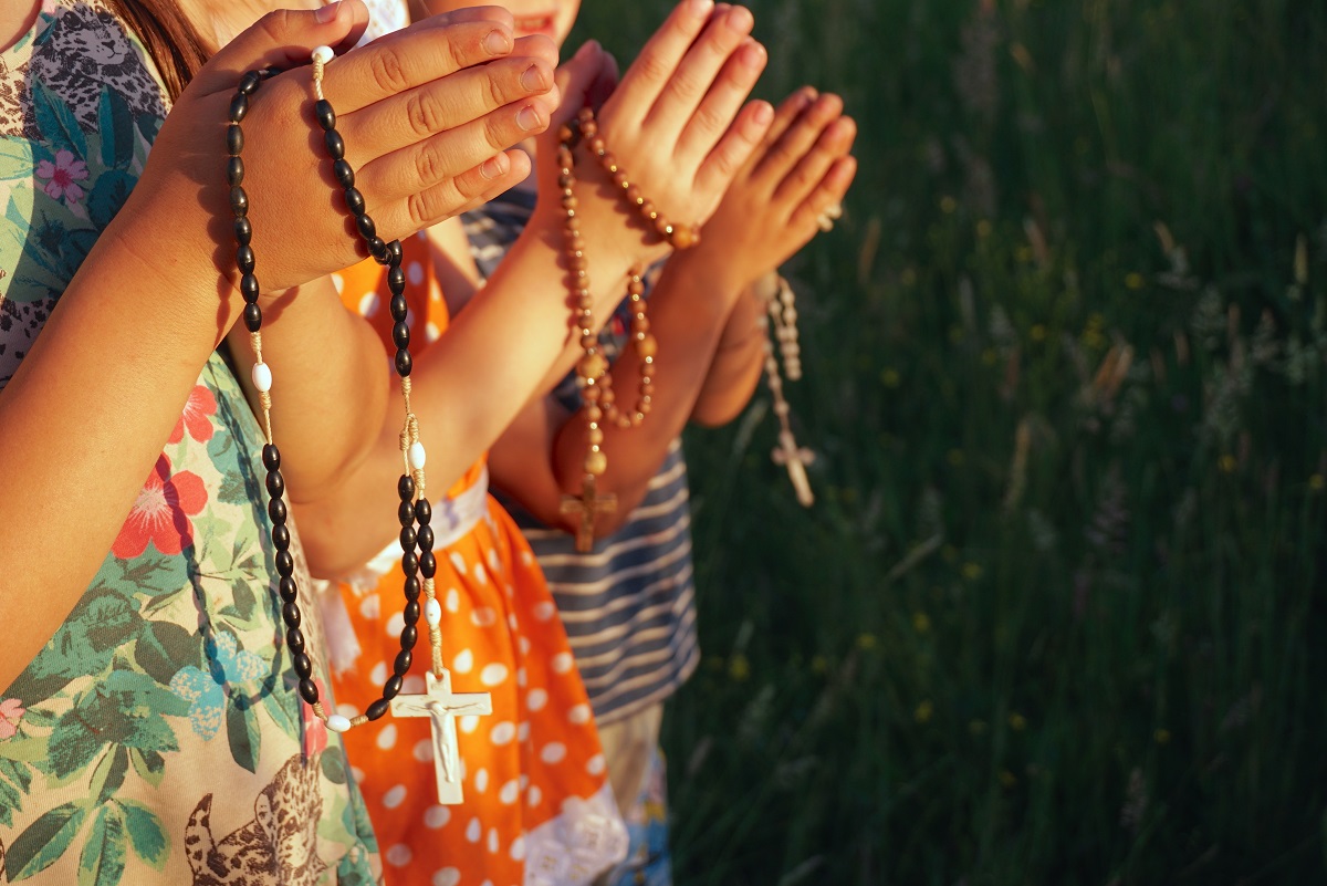 Kids hands praying rosary